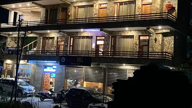 A multi-story building with balconies and a restaurant at the ground level. - Kasar Hill Top (Almora)