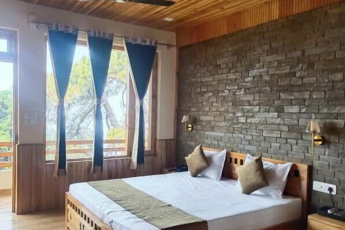 A wooden-paneled bedroom with a brick wall, a large bed, and a ceiling fan.