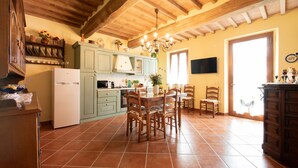 A kitchen with wooden beams, a dining table with chairs, and a refrigerator. - Luna Apartment with Swimming Pool (Porcari)