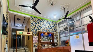A reception area with a reception desk, a staircase, and a fish tank. - Hotel Shri Ram By GRB (New Delhi)