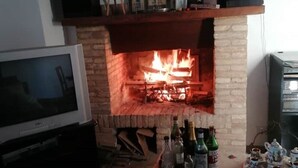 A fireplace with a TV on a stand in front of it.