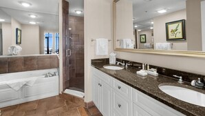 Een moderne badkamer met een dubbele wastafel, een grote spiegel en een ruime douche.