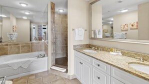 Ein modernes Badezimmer mit einer großzügigen Badewanne, einer begehbaren Dusche und einem Waschtisch mit einem großen Spiegel.