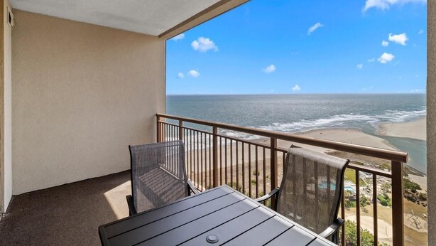 Ein Balkon mit Blick auf Strand und Meer.