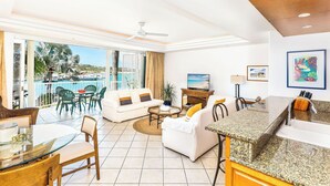 Amplia sala de estar con balcón, mesa de comedor y zona de cocina con lavaplatos.