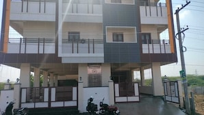 A multi-story building with a central courtyard, balconies, and a gated entrance. - Eben Residency (Chengalpattu)