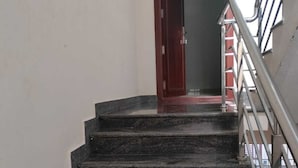 A staircase with a handrail and a door at the top. - Eben Residency (Chengalpattu)