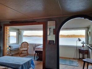 Enjoy a serene view of the lake from this inviting room, featuring a comfortable bed and a charming seating area.