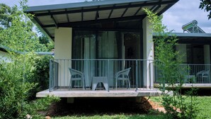 A modern house with a covered porch, two chairs, and a small garden area. - Don Bosco Hospitality Centre (Kigali)