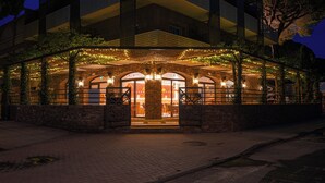 Un edificio con una zona esterna coperta, pareti in pietra e portali ad arco.