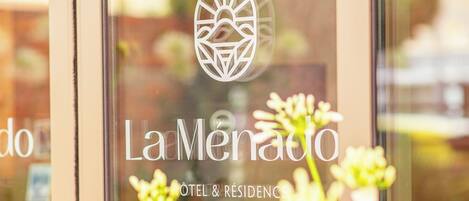 A hotel sign with the name "La Menado" and the words "HOTEL & RESIDENCE" indicating the type of accommodation.