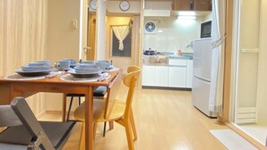 A compact living space with a dining area, kitchen, and a small balcony.