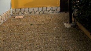 A paved outdoor area with a stone border and a yellow wall. - Apartment terasse Le Barcarès  (Le Barcarès)
