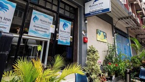 Ein Hotel Eingang mit Beschilderung, Sitzgelegenheiten im Freien und Topfpflanzen.