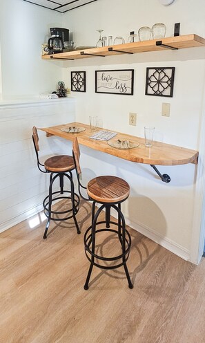 Enjoy cooking and dining in this well-equipped kitchen with a coffee maker, wine glass, and glasses on a shelf.