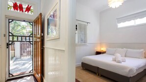 A bedroom with a bed, bedside table, and a window with blinds.