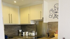 A modern kitchen with light-colored cabinets, a stainless steel refrigerator, a dishwasher, and a coffee maker. - Modern and bright studio (Cannes)