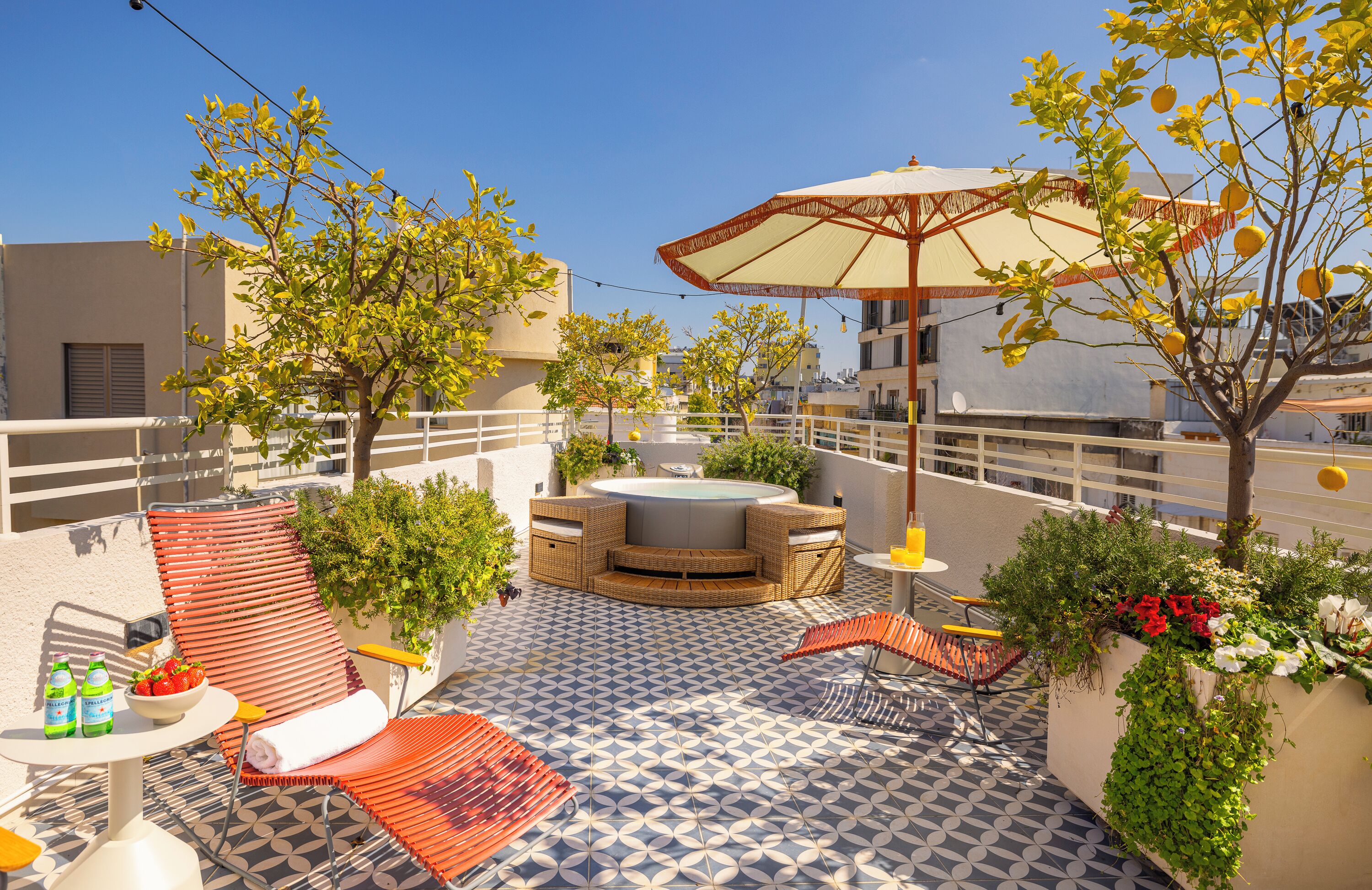 Terraço no telhado com área de estar externa, hidromassagem e plantas em vasos.