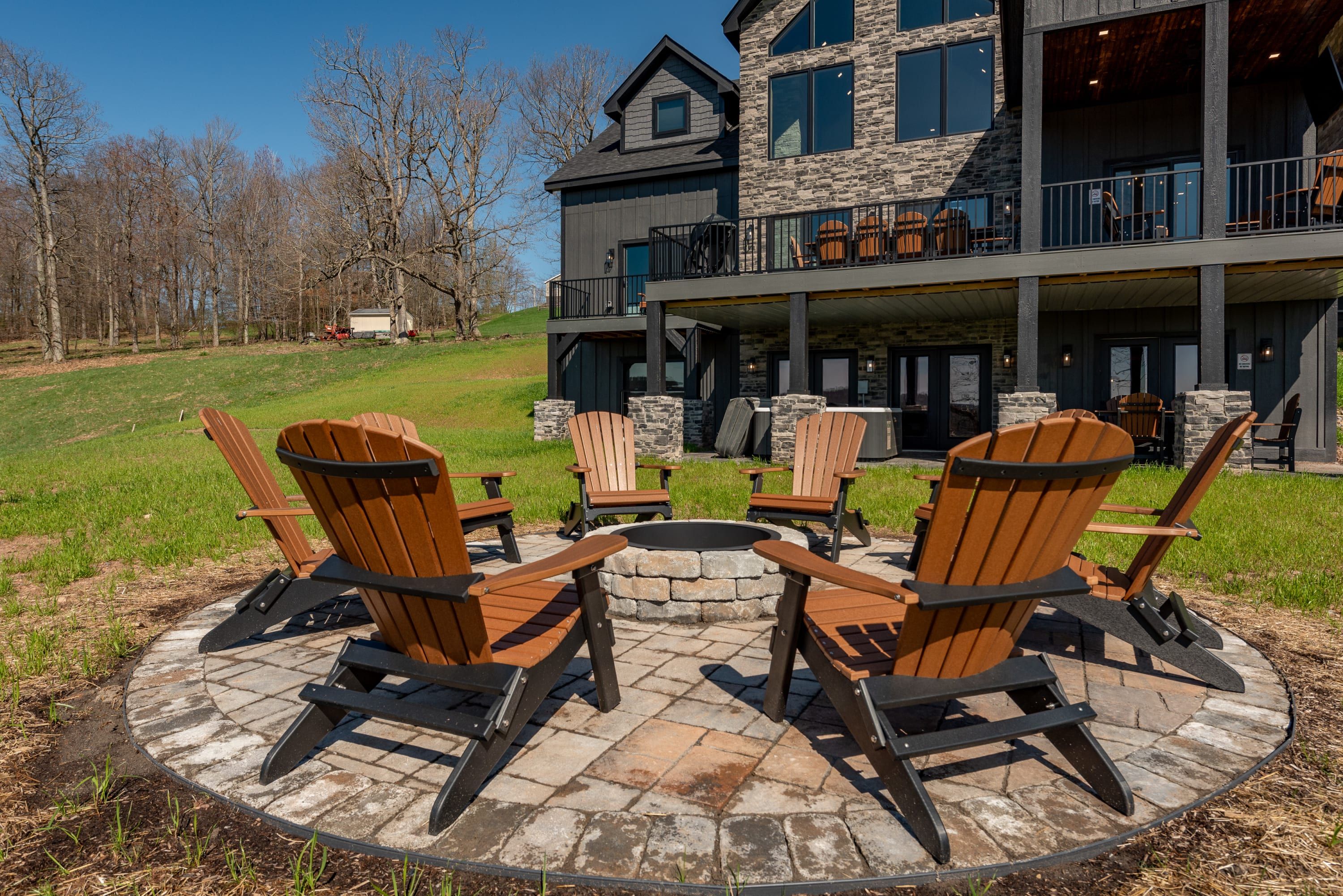 A modern two-story house with a stone facade and a large deck area.