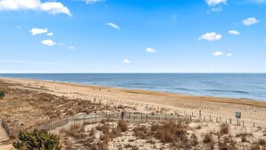 A beach with a wooden fence, sandy dunes, and the ocean. - Windbreaker - Amazing Views From This 1 Bedroom Oceanfront Condo (Ocean City)