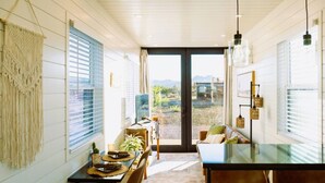 A dining area with a table, chairs, and a view of the outdoors. - Somewhere in Texas Container Home (Alpine)