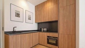 Une cuisine moderne avec des meubles en bois, un four encastré et un four à micro-ondes.