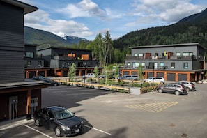 A modern hotel with multiple floors, outdoor seating, and a parking area.