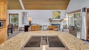 A modern kitchen with a central island, wooden ceiling, and a stone backsplash. - Updated, great location, by Sharc and Village mall (Sunriver)