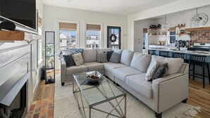 A modern living room with a sofa, coffee table, and fireplace.
