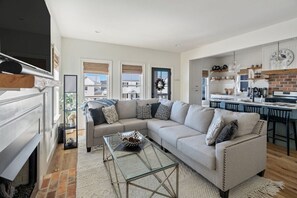 A modern living room with a sofa, coffee table, and fireplace.
