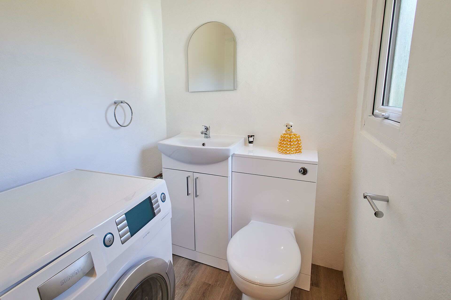 Un baño pequeño con lavadora, lavamanos e inodoro.