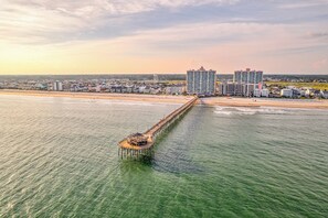 A pier extending into the water with buildings in the background. - Serenity Hideaway: Oceanfront w/ Pool & Stunning Views (North Myrtle Beach)