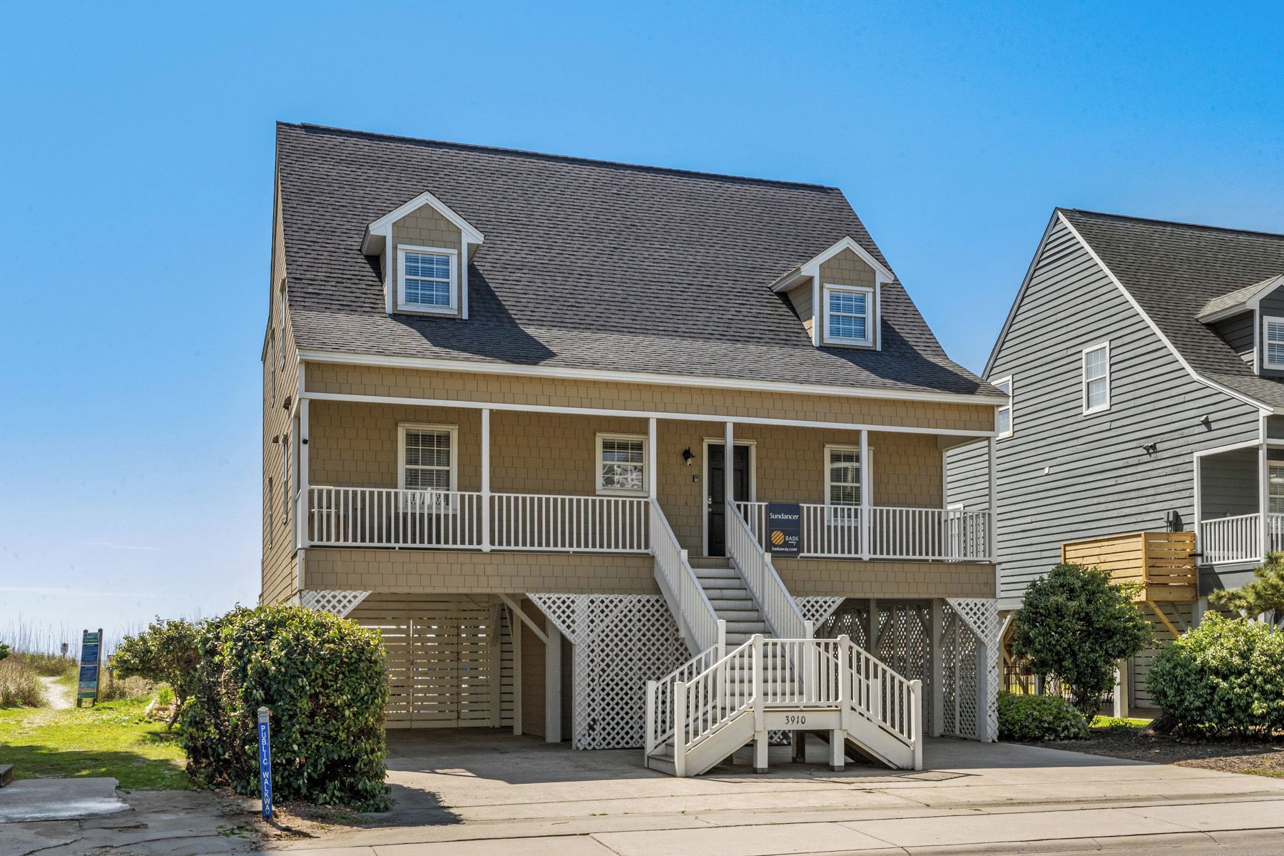 A two-story residential building with a balcony, a covered front porch, and a staircase leading to the entrance.