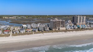 A coastal hotel with multiple buildings, beachfront access, and a view of the ocean.