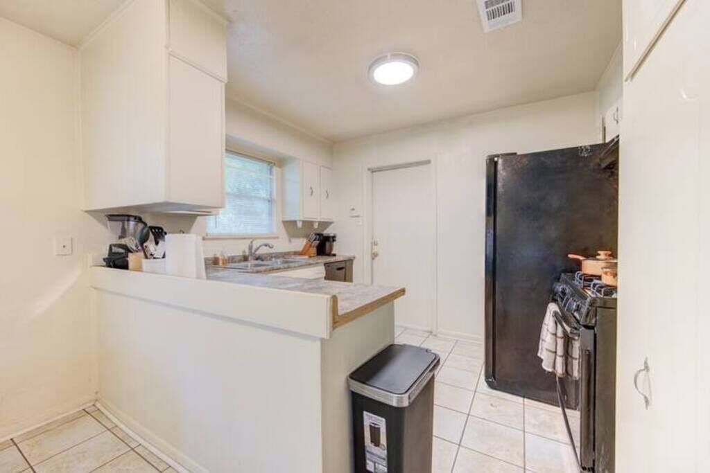 A compact kitchen with a central island, a built-in oven, and a refrigerator.
