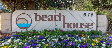 A beach house sign with a water icon and the number 675.