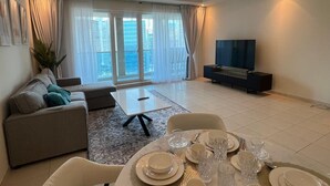 Departamento Confort, balcón, vista al lago | Área de sala de estar | Smart TV de 65 pulgadas con canales por cable 