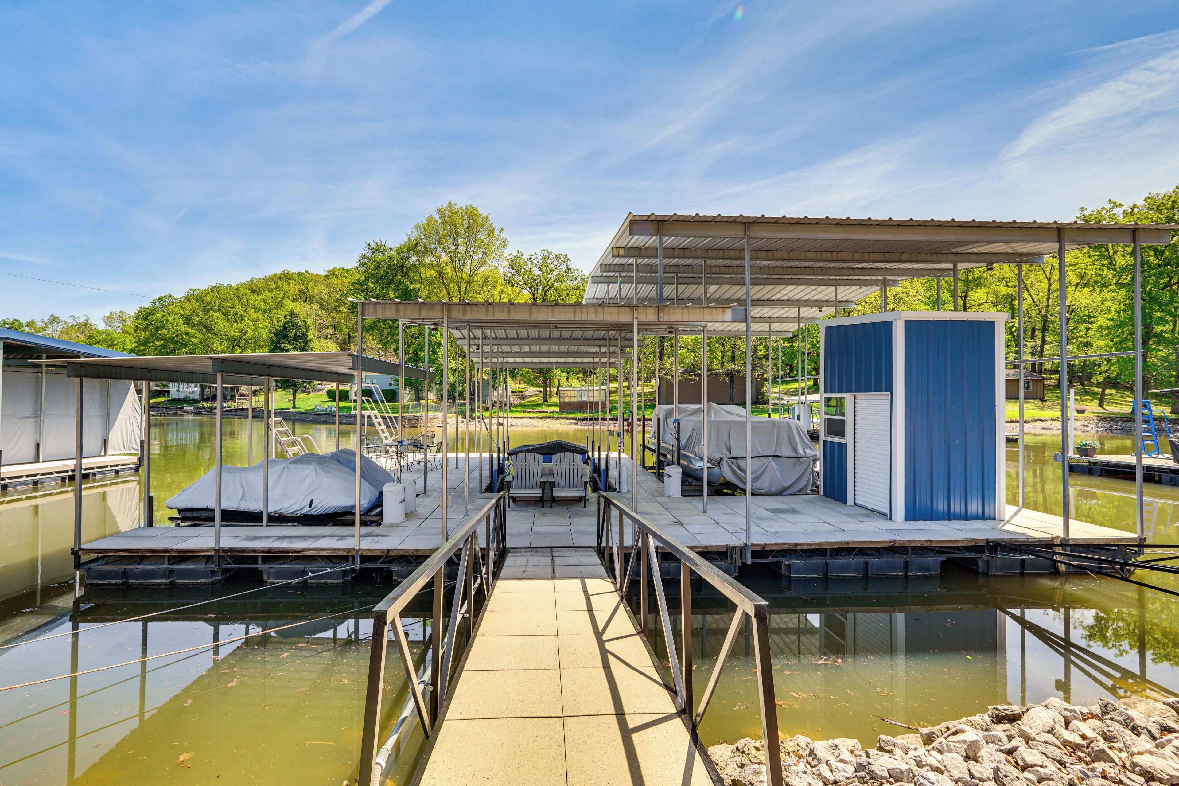A marina with docked boats, covered seating areas, and a small building.