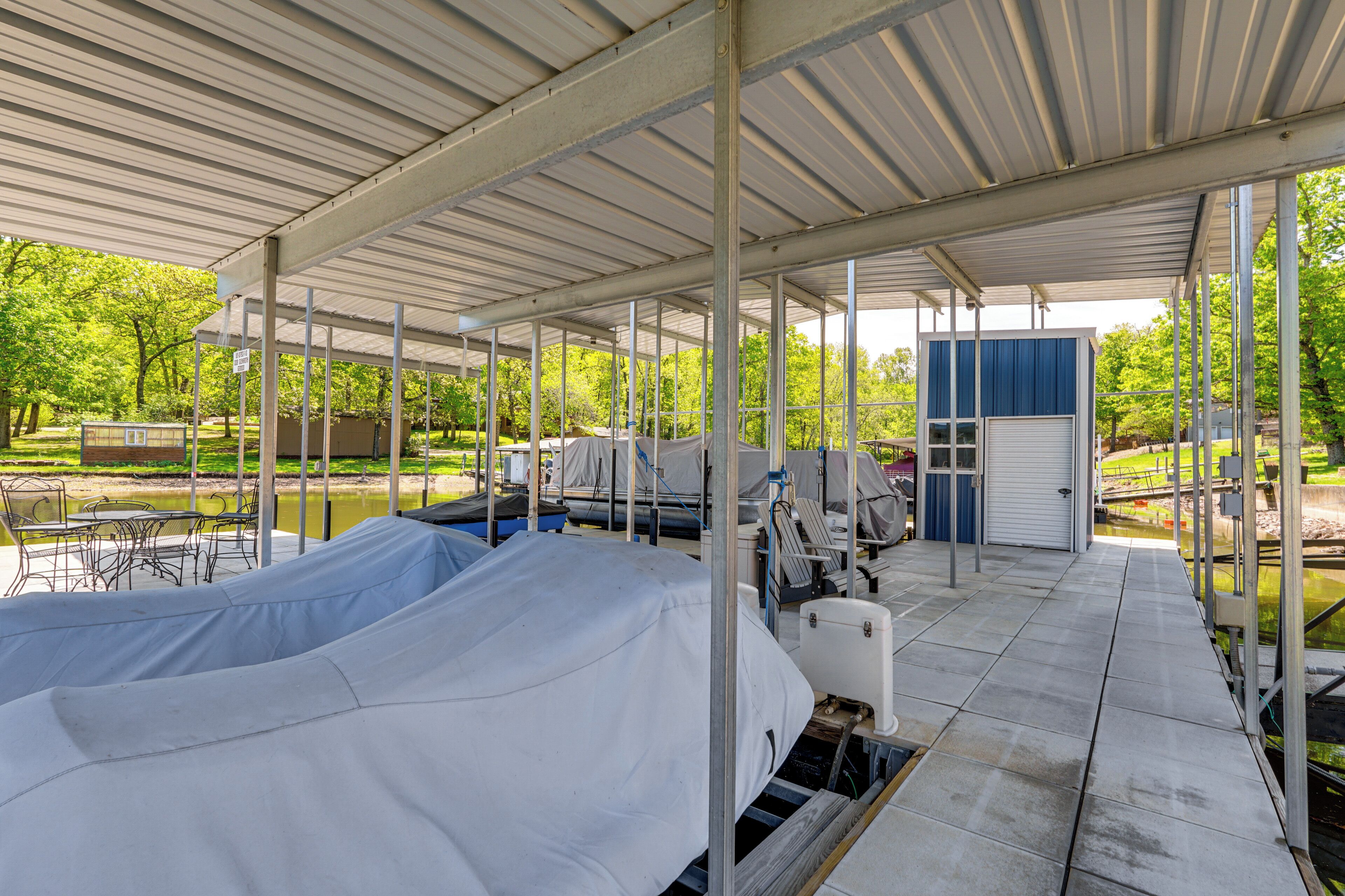 A covered outdoor area with seating and a small building.