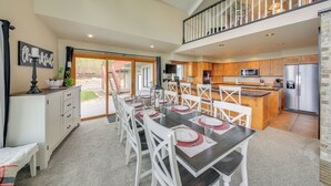 A spacious kitchen with a dining area, featuring a large island, wooden cabinets, and a stainless steel refrigerator. - Beachfront Sagle Retreat w/ Boat Dock & Lift (Sagle)