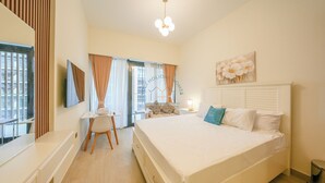 Une chambre moderne avec un lit, un bureau et une chaise. Il y a une fenêtre avec des rideaux, un tableau au mur et un luminaire au plafond.