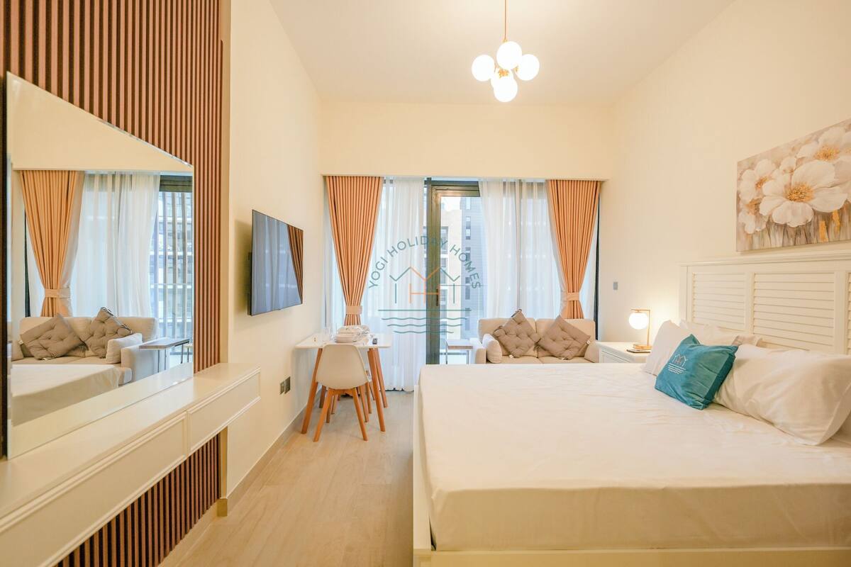 Une chambre d’hôtel moderne équipée d’un lit, d’un bureau, d’une chaise et d’un téléviseur.