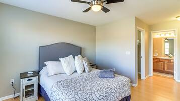 A bedroom with a bed, nightstand, and a ceiling fan.