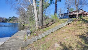 Un escalier en bois menant à une maison située au bord d’un lac.