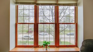 A window with a wooden frame and a plant on the sill. - Pet-friendly New Kensington Apt w/ Shared Perks (New Kensington)