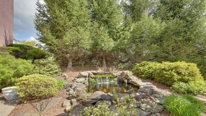 A garden with a pond, surrounded by various plants and trees. - Day Trip to Pittsburgh: Comfy New Kensington Apt! (New Kensington)