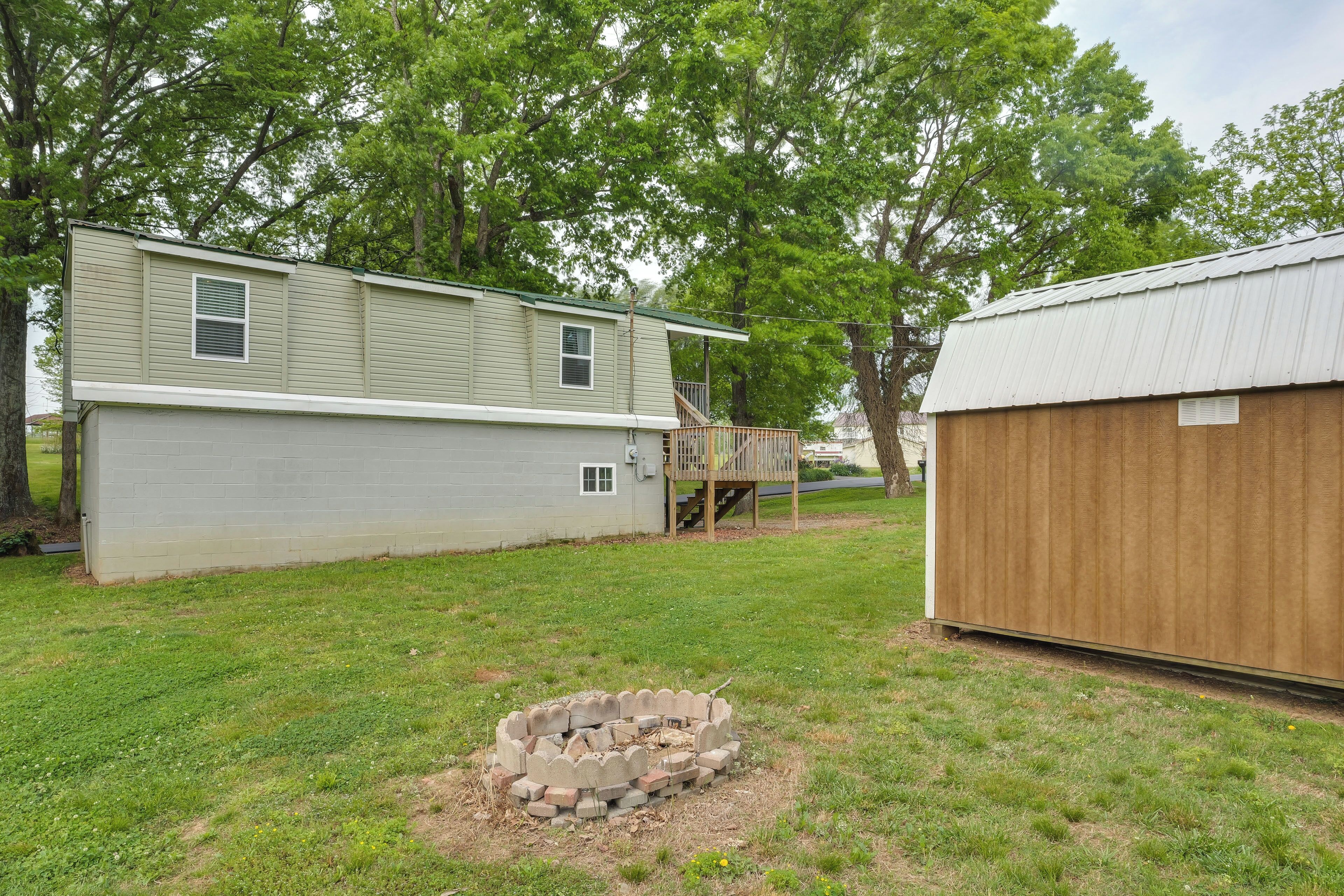 A two-story house with a fenced yard, a wooden deck, and a shed.