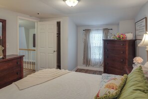 Um quarto com cama, cômoda e armário.