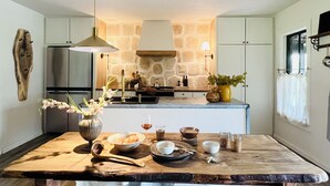 Une cuisine moderne avec un mur en pierre, une table en bois et divers ustensiles de cuisine.
