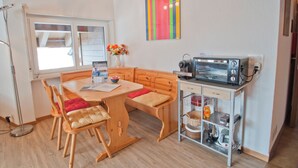 A cozy kitchen with wooden furniture, a microwave, and a small cabinet with kitchen items. - Studio Riffelsee (Zermatt)